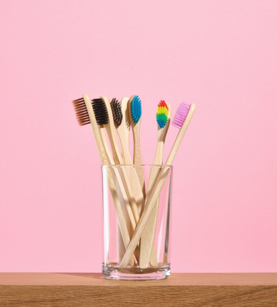 Eco friendly oral care tools. Toothbrushes with colorful bristles in glass.