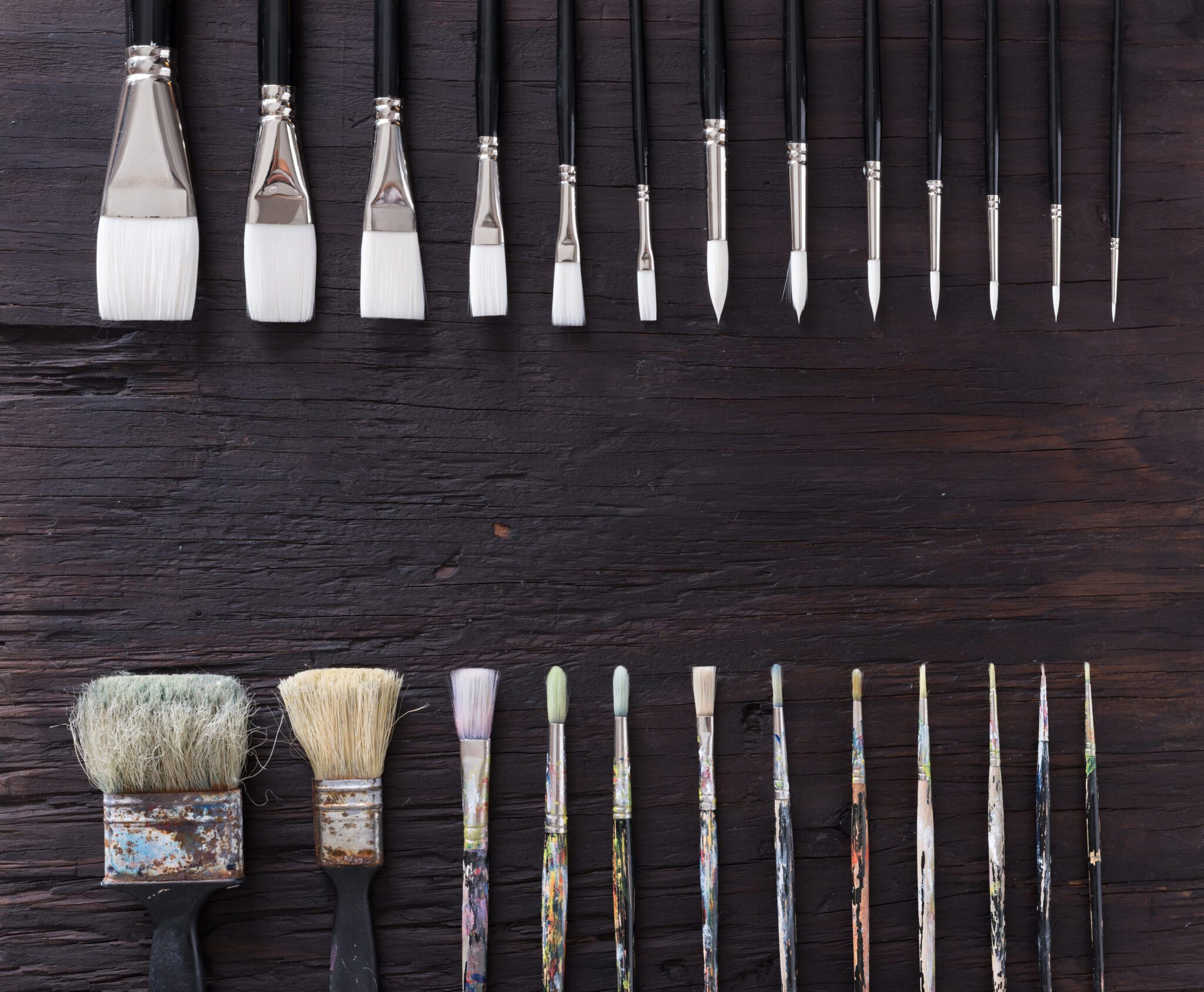 Paint brush on old wood black vintage aged texture background.